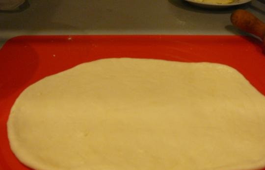 1. Этап. Конвертики с сыром: 5. Тесто раскатать пластом и разделить на 2 части, каждую из которых скатать рулетиком.