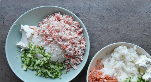 1. Этап. Ленивые роллы: Готовый рис делю на две части. В обе части добавляю по половине нарезанного свежего огурца, творожного сыра, васаби, измельченные водоросли нори. В одну часть добавляю нарезанные крабовые палочки. Во вторую миску добавляю мелко нарезанную слабосоленую форель. Обе массы тщательно перемешиваю.