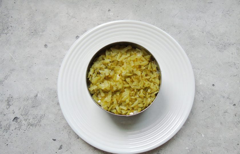 1. Этап. Слоеный салат Лесная поляна с маринованными опятами: Соленый или маринованный огурец натрите на терке с крупными отверстиями. Выложите на слой яиц, смажьте майонезом.