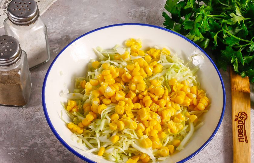1. Этап. Салат из капусты с кукурузой и яйцом: Консервированную кукурузу откиньте на дуршлаг, сцеживая маринад. Затем добавьте ее к капусте.