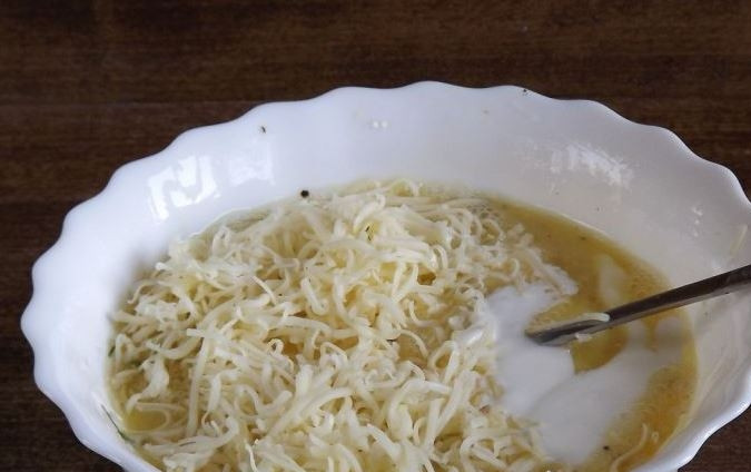 1. Этап. Запеканка овощная с сыром: К яйцам добавьте сметану. Она может быть как жирной, так и с пониженным содержанием жиров. Натрите на мелкой терке любой твердый сыр. Добавьте его к остальным ингредиентам и тщательно все перемешайте.