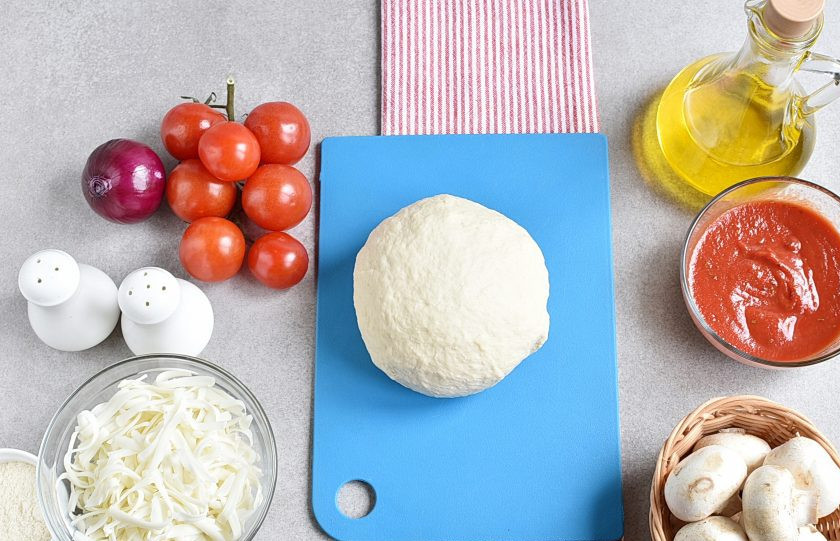 1. Этап. Пицца с шампиньонами: Смазав руки остатками оливкового масла, хорошо вымесите тесто. Оно должно стать абсолютно гладким и не липнуть к рукам.