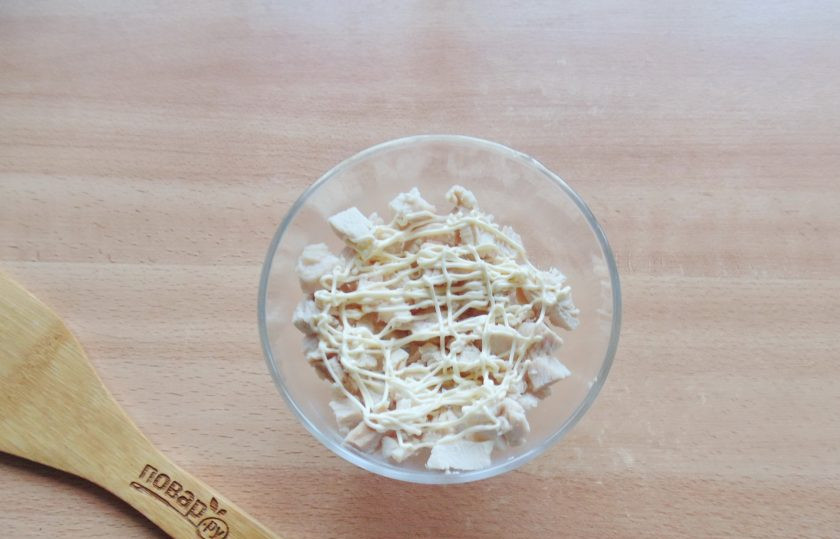 1. Этап. Салат с курицей, киви и грибами: Курицу отварите в подсоленной воде. Охладите и мелко нарежьте. Выложите в салатник или креманки. Покройте майонезом.