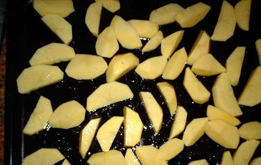 1. Этап. Картофель с сосисками в духовке: 2. Картофель необходимо вымыть и очистить. Нарезать средними кусочками и выложить в глубокую мисочку. Подсолить по вкусу и взбрызнуть растительным маслом. При желании в рецепт приготовления картофеля с сосисками в духовке можно добавить немного сметаны или майонеза. Противень смазать маслом и выложить картофель.