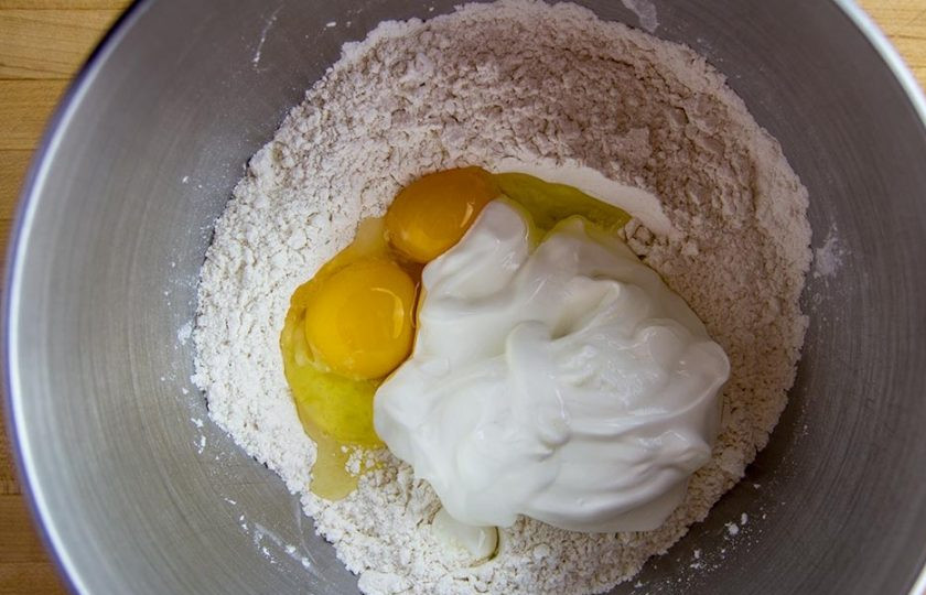 1. Этап. Вареники с картошкой и квашеной капустой: 4. В миску просейте муку, добавьте целое яйцо и куриный желток, а также сметану, разрыхлитель, соль.