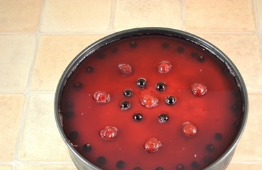 1. Этап. Желе на торт: Смородину и вишню красиво разложите на основе торта. Сверху залейте желе.