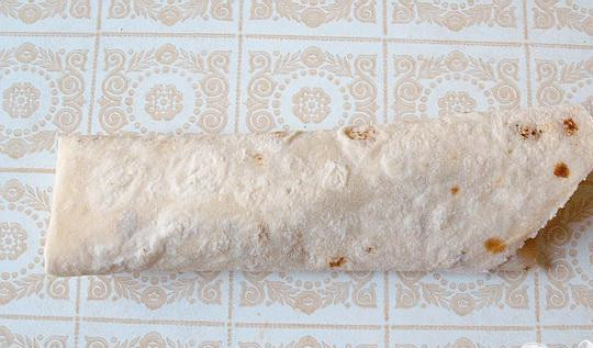 1. Этап. Рулеты из лаваша с квашеной капустой и мясом: 5. Края отрезанного лаваша подгибаем и заворачиваем в рулет. Взбиваем яйца с молоком и солью. Смазываем форму, выкладываем туда рулеты. Обмазываем их смесью из молока и яиц. Рулет заливаем остатком смеси.