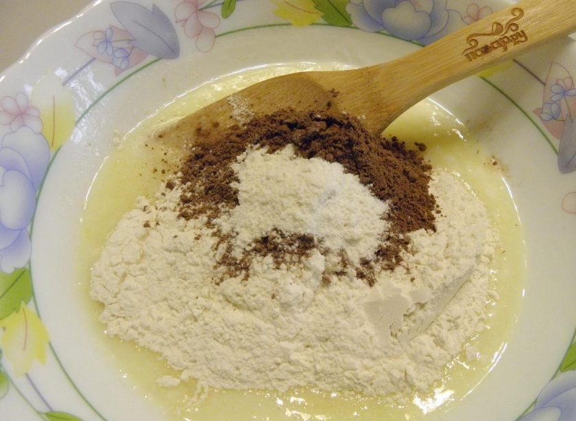 1. Этап. Сметанник шоколадный: 3. Добавьте просеянную муку, какао-порошок и разрыхлитель. Смешайте все ингредиенты до получения однородного теста. Муки не нужно добавлять больше, иначе тесто будет вздуваться во время выпечки и торт не будет ровным.