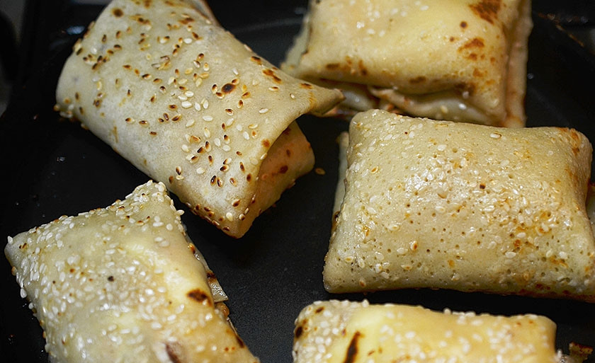 1. Этап. Творожные блины с кунжутом и изюмом: 8. Выложите блинчики с творогом в сковороду и обжаривайте до золотистого цвета.