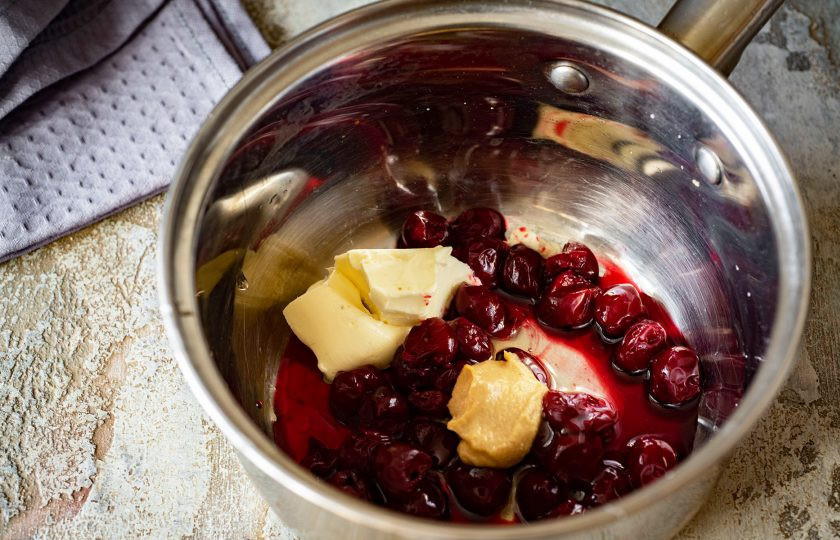 1. Этап. Нежная говядина под ягодным соусом: Приготовьте пикантный ягодный соус. Я готовлю соус из замороженной вишни. В небольшую кастрюльку выложите ягоды, сливочное масло (20 грамм), жидкий мед, горчицу, перец черный молотый (1/2 ч.л.).