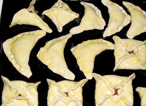 1. Этап. Слоеные пирожки с мясом: Выложите пирожки на противень смазанный растительным маслом.