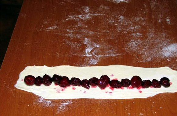 1. Этап. Торт Дрова под снегом: Распределяем вишенки на полоске теста.