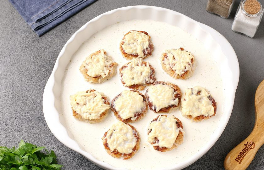 1. Этап. Куриные тефтели в духовке в сливочно-сырном соусе: Переложите тефтели в жаропрочную форму и полейте приготовленным сливочно-сырным соусом. Запекайте в разогретой до 200 градусов духовке около 20 минут.