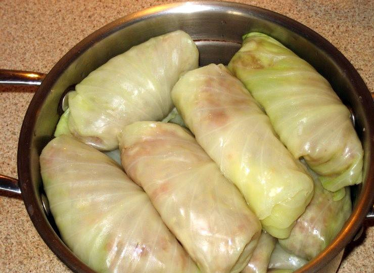 1. Этап. Голубцы по-украински: 4. Заворачиваем каждый лист с начинкой конвертом и складываем в кастрюлю, в которой будут тушиться голубцы. Отдельно делаем соус: пережариваем лук и морковь, добавляем томатную пасту и заливаем водой. Доводим до кипения и заливаем соусом голубцы. Ставим тушиться на средний огонь. Готовятся они около получаса.