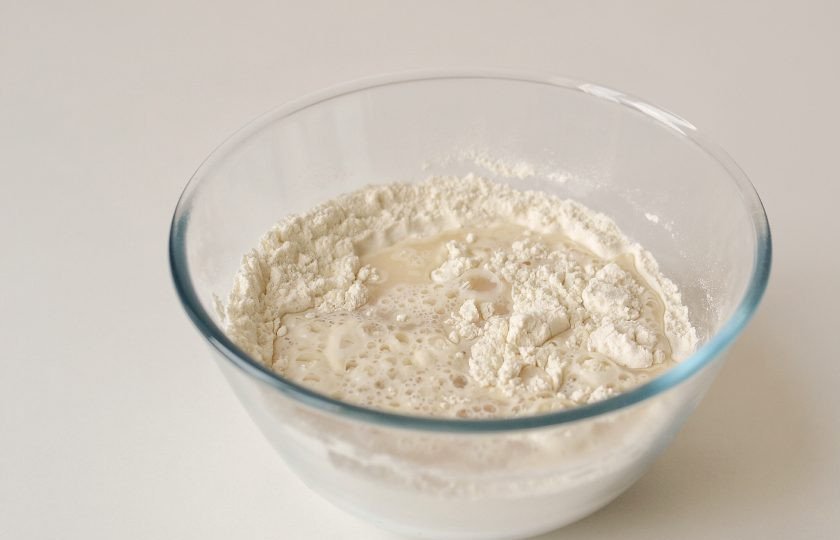 1. Этап. Хлеб с манкой: Просейте муку с разрыхлителем и солью. Влейте воду с дрожжами и замесите тесто.