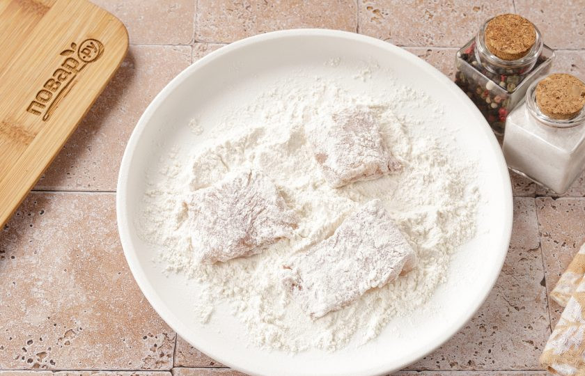 1. Этап. Минтай тушёный с перцем: Затем обваляйте каждый кусочек в муке и обжарьте с двух сторон на сковороде до золотистого цвета.