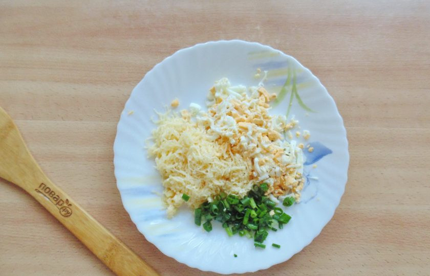 1. Этап. Зразы из судака: Яйца сварите вкрутую, охладите и очистите. Натрите на терке яйца и твердый сыр. Зеленый лук мелко нарежьте.