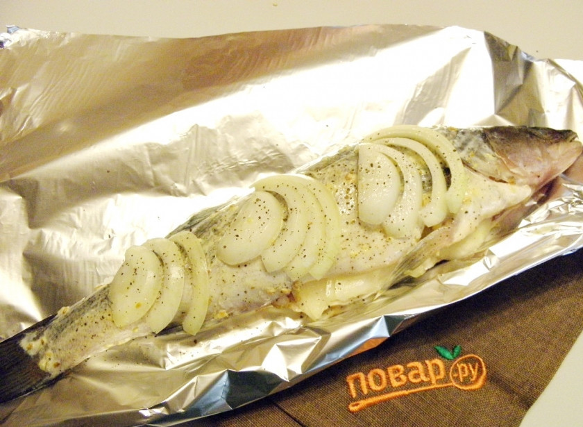 1. Этап. Судак в духовке, запеченный в фольге: Луковицу порежьте крупными полукольцами, посолите чуточку и вложите в брюшко судаку. Для украшения можно сверху положить несколько ломтиков.