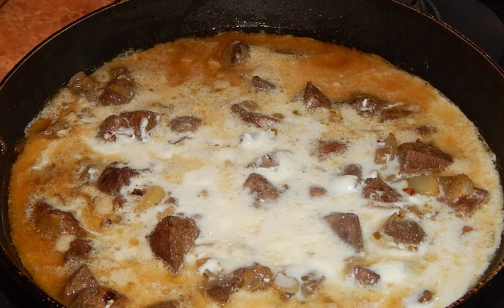 1. Этап. Печень со сметаной: Вливаем сметанный соус к печени, добавляем муку, перемешиваем и тушим 15 минут.