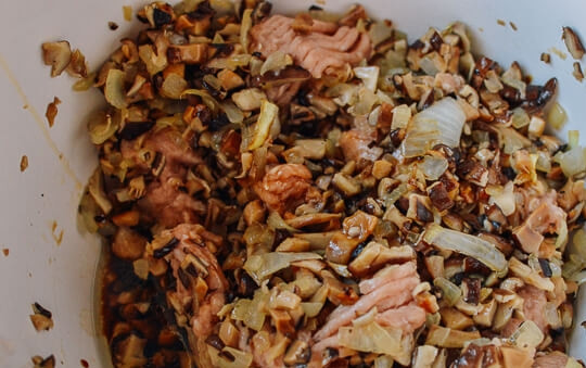 1. Этап. Жаренные китайские пельмени: В глубокой миске смешайте обжаренные с луком грибы, куриный фарш, сахар, соевый соус и вино. Хорошенько все перемешайте.