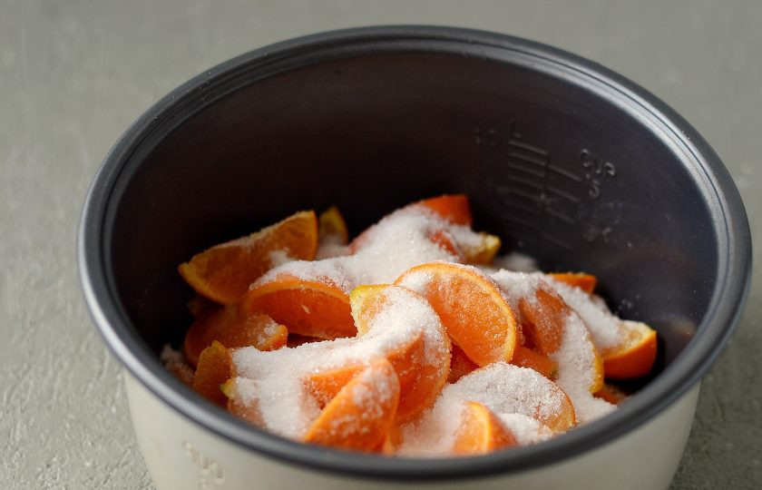 1. Этап. Варенье из мандаринов дольками в мультиварке: Выложите в чашу мультиварки мандарины и сахар.