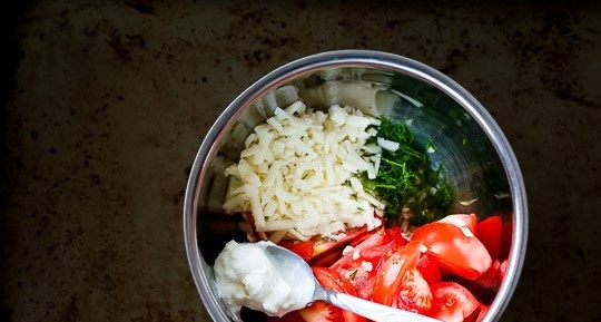 1. Этап. Легкий и быстрый салат: В миску натрите сыр на крупной тёрке. Добавьте измельчённый укроп и чеснок, помидоры и йогурт.