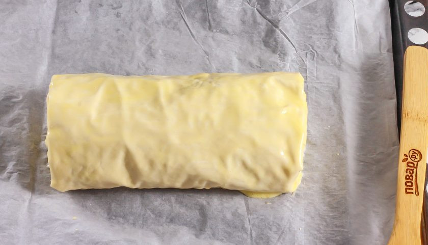 1. Этап. Рулет с яблоком и орехами: Выложите на противень и смажьте взбитой яичной смесью со всех сторон.