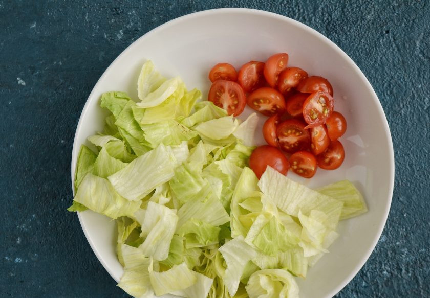 1. Этап. Постный Цезарь: Помидоры разрежьте пополам, салат айсберг нарежьте на прямоугольные ломтики.