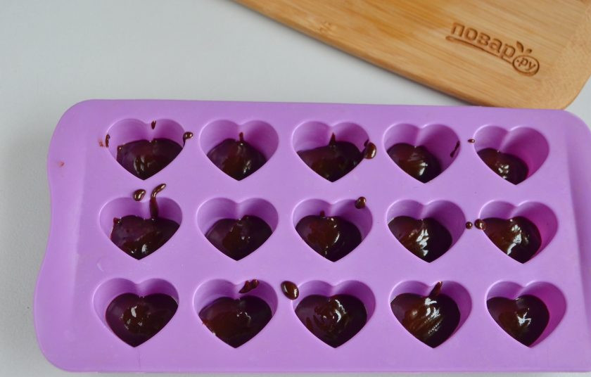 1. Этап. Конфеты Чизкейк в шоколаде: Растопите шоколад, в каждую ячейку влейте немного горячего шоколада.