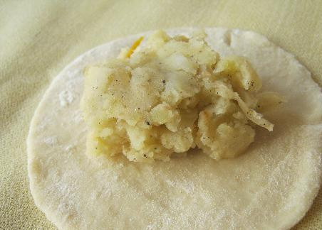 1. Этап. Пирожки на соде: Разделайте тесто на лепешки и положите на них начинку.