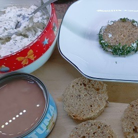 1. Этап. Закусочные бутерброды с тунцом: Из хлеба вырежьте кружочки. Бока смажьте сырной массой и обсыпьте укрупом.