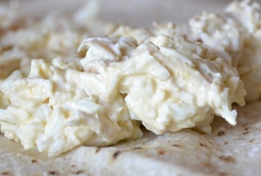 1. Этап. Лаваш с плавленым сыром и яйцом: 4. Выложите лист лаваша, а на него — часть начинки. Аккуратно сверните рулетом.