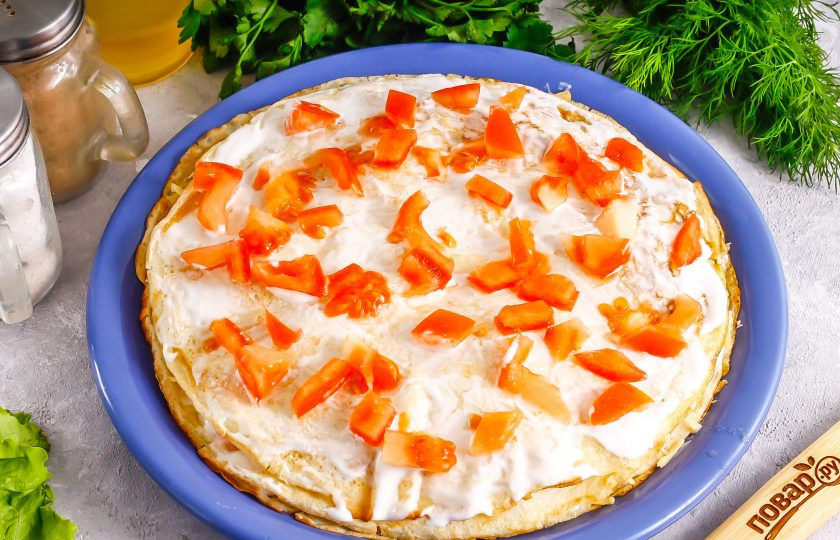 1. Этап. Блинный торт с ветчиной и сыром: Третий слой — нарежьте промытый и очищенный от сердцевинки помидор кубиками и выложите его на смазанный сметаной блин.