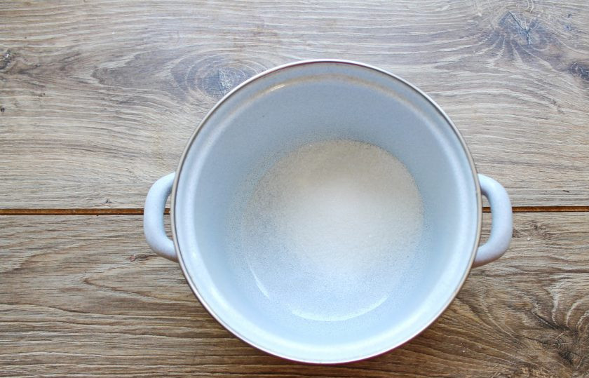 1. Этап. Компот из смородины и крыжовника: В кастрюлю всыпьте сахар и влейте воду. Поставьте кастрюлю на средний огонь и доведите до кипения.