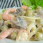 Салат Елисейский Лук нужно нарезать полукольцами и обжарить до готовности. Шампиньоны нарезать на небольшие дольки и тоже жарить до готовности. Креветки можно взять готовые. У меня было полкило свежемороженых креветок. После разморозки и варки в кипящей соленой воде (буквально 1 минутку!) и очистки их осталось как раз около 150 граммов. Для заправки нужно взять 2 ложки густых сливок, хорошо поперчить, выжать немного (около чайной ложки) лимонного сока и посолить. Остывшие ингредиенты заправить соусом и перемешать.