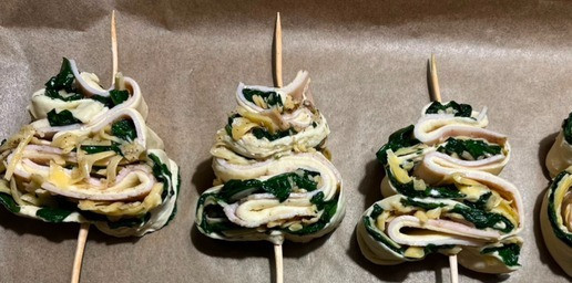 1. Этап. Елочки со шпинатом и индейкой: Из полосок теста сформировать ёлочки. Для этого выложить полоску теста начинкой (срезом) вверх. Уложить тесто 