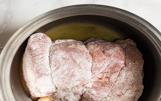 1. Этап. Мясо в красном вине: Мякоть говядины нашпигуйте салом и обвяжите кулинарным шпагатом. Получившийся «рулет» обваляйте в муке со всех сторон. В казанчик или утятницу влейте оливковое масло, положите сливочное масло и подготовленное мясо.