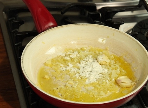 1. Этап. Баранина по-узбекски: В сковороде обжарить лук и чеснок. Затем добавить муку, обжарить, быстро перемешивая, и залить небольшим количеством (полстакана) бульона.