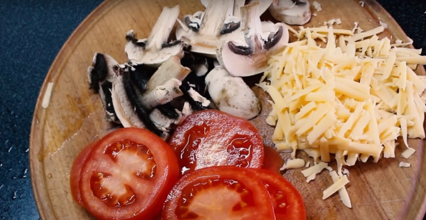 1. Этап. ПП пицца без теста: 4. За это время подготовьте начинку: помидор, шампиньоны, сыр. Помидор с грибами нарежьте кружочками и пластинами соответственно. Сыр натрите на терке.