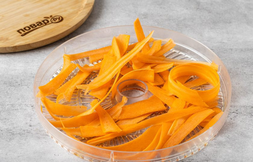 1. Этап. Сухой овощной бульон: Морковь помойте, очистите от кожуры и нарежьте тонкими лентами. Выложите на решетку сушилки в один слой.