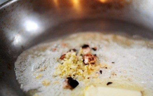 1. Этап. Конвертики с грибами: Масло растопить в сковородке, добавить чеснок и немного пожарить на медленном огне.