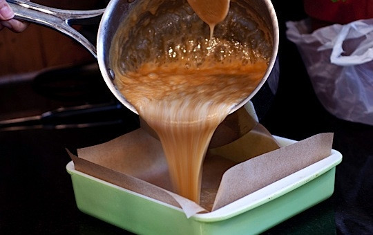 1. Этап. Самодельные конфеты: Тем временем подготовьте форму. Выстелите ее пергаментной бумагой так, чтобы все стенки формы были закрыты. Когда масса достигнет нужной температуры, добавьте ванилин, перемешайте и перелейте все в форму.