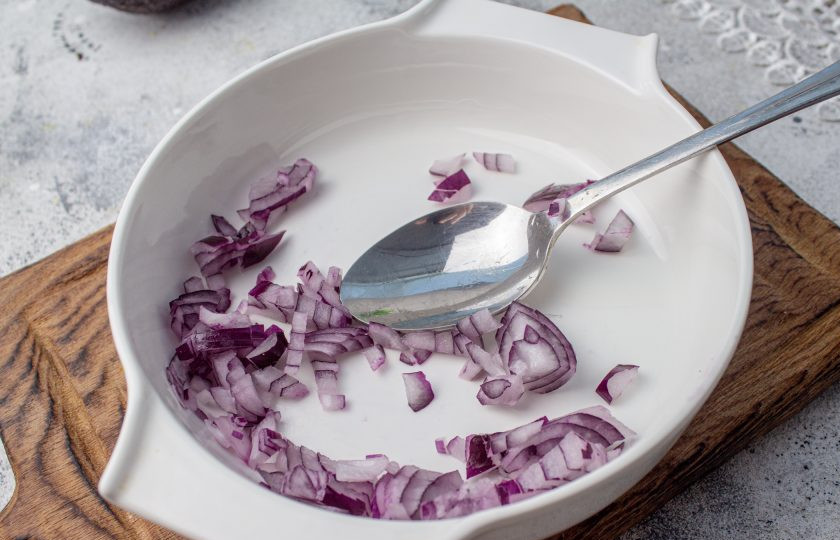 1. Этап. Праздничный легкий салат с семгой и авокадо: Половину красного лука нарежьте мелким кубиком, выложите в миску.