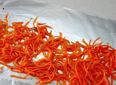 1. Этап. Кефаль в духовке в фольге: Ставим духовку разогреваться на 200 градусов. На столе расстилаем лист фольги и выкладываем половину моркови по-корейски.