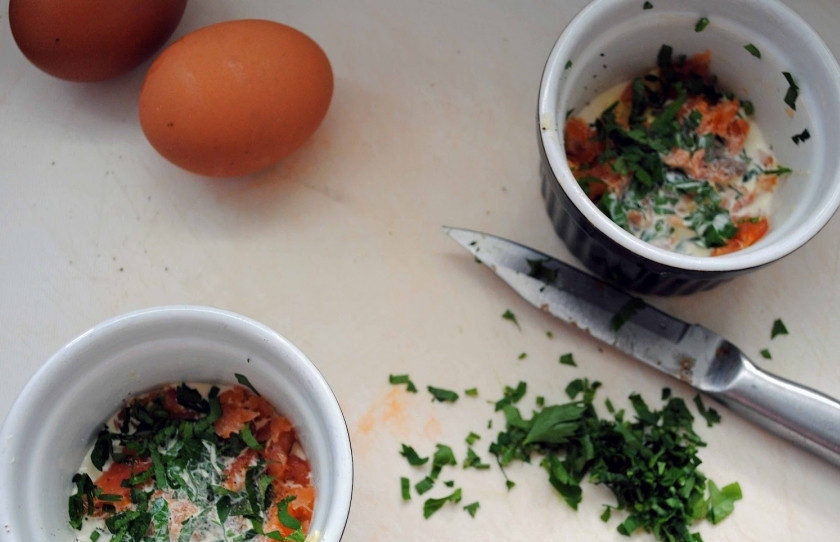 1. Этап. Омлет с семгой в духовке: Приступим. Растопите сливочное масло, разлейте его по формочкам для омлета, выложите туда же мелко нарубленную сёмгу и петрушку.