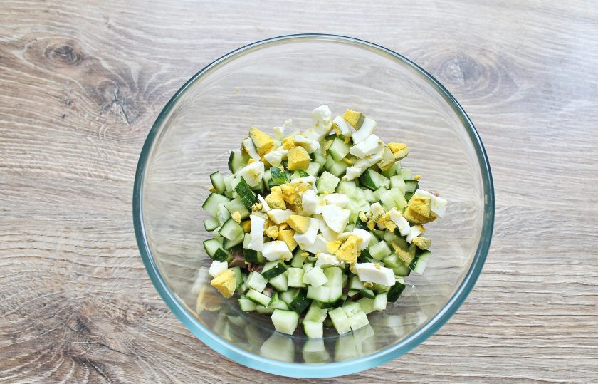 1. Этап. Салат с языком и кедровыми орешками: Яйцо очистите, порубите и добавьте в миску с языком и огурцом.