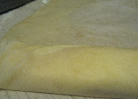 1. Этап. Выпечка из теста фило: 9. Вторую часть теста положите на стол, на край выложите часть начинки, плотно заверните в «рулет». Перед укладыванием начинки немного смажьте пласты теста фило маслом.