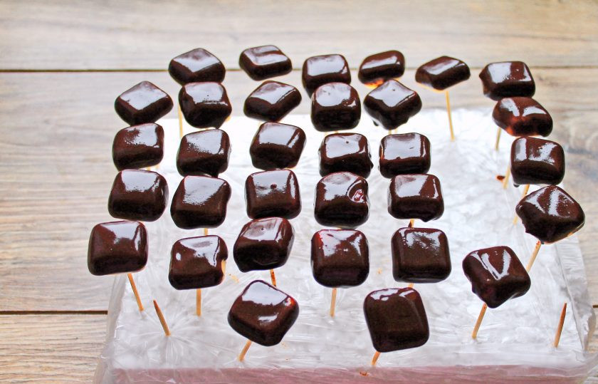 1. Этап. Конфеты с манго: Шоколад измельчите и растопите на водяной бане. Конфеты со стороны дна наколите на зубочистки и окуните, оставляя верх, в шоколад. Вставьте зубочистки в подходящий материал и оставьте до застывания.