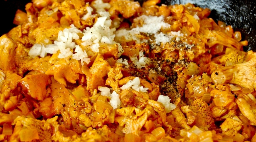 1. Этап. Лисички в сметане по-украински: Затем крышку снимаем, жидкость выпариваем, добавляем мелко нарезанный чеснок и готовим еще минут 10. Лисички уже хорошо потушились, однако теперь их нужно слегка обжарить - поэтому мы выпариваем жидкость и немного зажариваем их.