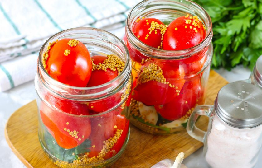 1. Этап. Помидоры с семенами горчицы на зиму: В банки с пропаренными томатами всыпьте зерна горчицы, горошины черного перца.